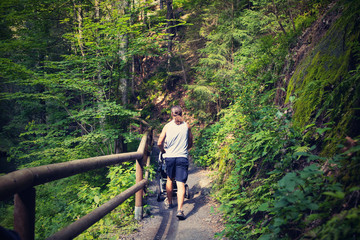 A man with a pram on the tourist route.Czech Switzerland National Park. A national park famous for its sandstone formations, wild valleys and frozen waterfalls.