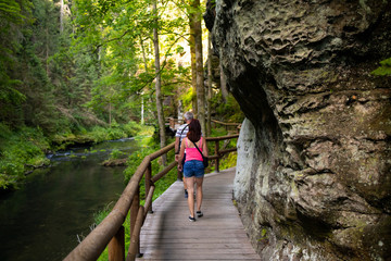 Youth on the tourist route.Footbridge in the tourist route among rocks and trees.Czech Switzerland National Park. A national park famous for its sandstone formations, wild valleys and frozen waterfall