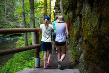 Youth on the tourist route.Footbridge in the tourist route among rocks and trees.Czech Switzerland National Park. A national park famous for its sandstone formations, wild valleys and frozen waterfall
