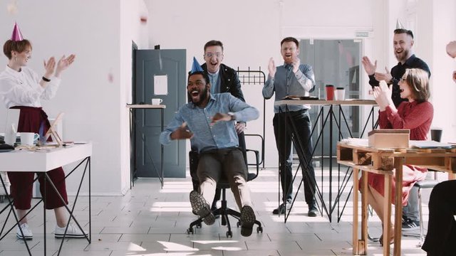 RED EPIC-W Happy young black businessman celebrating birthday at office workplace party with confetti slow motion.