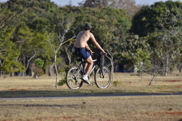 Fototapeta na wymiar A beautiful view of people walking with bike in Brasilia park, Brazil