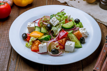 Greek salad with feta on wooden table