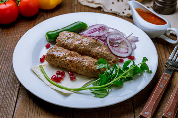 Lamb Lula kebab on white plate on wooden table