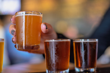 closeup of hand holding a small sample beer glass