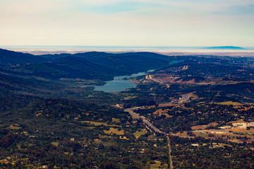Aerial View Flying over San Mateo County with a Lake and the Foggy Marine Layer in the Horizon in the San Francisco Bay Area, California, USA