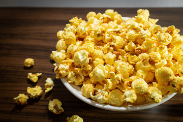Popcorn in a bowl, placed on a wooden table