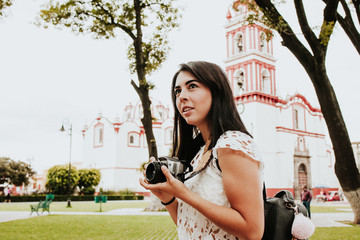 Hispanic girl Making pictures with travel camera in a Mexico trip, summer vacations in latin america