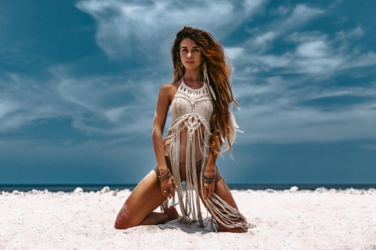 beautiful young woman in white exotic dress on the beach