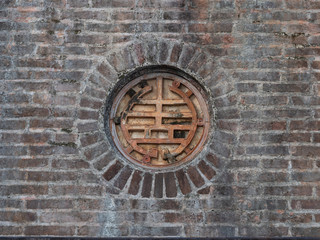 Close Up of Old Metal Medallion in Brick Wall