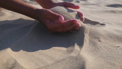 Sand in the hands. Close up view of sand running through a hands.
