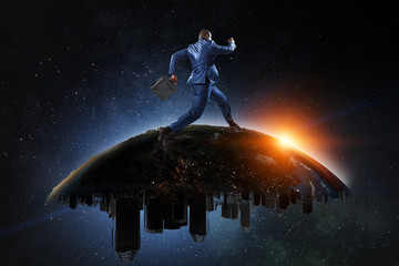 Obraz na płótnie Canvas Back view of a black businessman running on the Globe with city scyscrapers on the starry space background