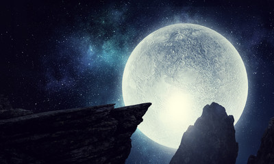 Mountain peaks on dark starry sky with full Moon