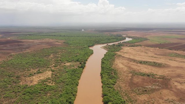 Retreating aerial footage of rural fields near the Omo river, agriculture and irrigation in Southern Ethiopia Africa
