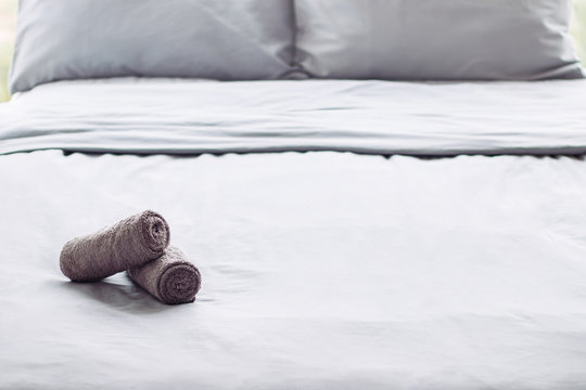 grey clean perfect bed, ready for guests, hotel room, towel, linens, background