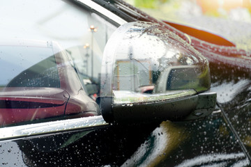 Obraz premium Abstract Double Exposure Road traffic that is transmitted from the parked glass of car black color with drop water.