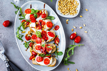 Italienisches Bruschetta mit gehackten Tomaten, Basilikum und Mozzarella auf gegrilltem knusprigem...