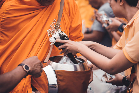 Put alms to make merit in Buddhism