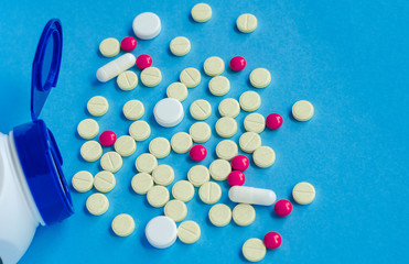 Different pharmaceutical pills and capsules from a jar.