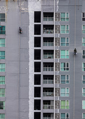 A painter was climbing the new building to painted on the facade of a high-rise building
