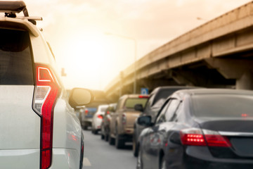 Brake of white car on asphalt roads during rush hours for travel or business work.There are different levels of bridges on the side.