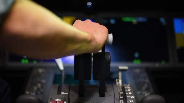 Man moving throttles forward and back on a twin engine commercial aircraft. 24 fps.