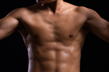 Fototapeta na wymiar Sweat. Closeup of a strength fitness body with sweat. Fit young man with beautiful torso. Bodybuilder and muscular body concept.