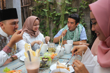 group of happy young muslim having dinner outdoor during ramadan celebration