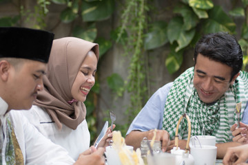 group of happy young muslim eating food outdoor