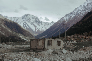 Abandoned and destroyed building in front of big mountains
