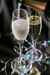 Vertical image of two glass cups with a luxurious and sparkling champagne. Concept of Christmas celebration. Aerial view