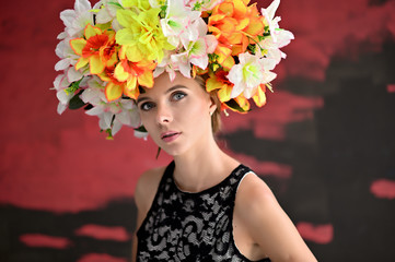 Portrait of a beautiful girl on a colored background with a wreath of flowers on her head. Beauty...