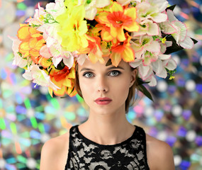 Portrait of a beautiful girl on a colored background with a wreath of flowers on her head. Beauty and brightness.