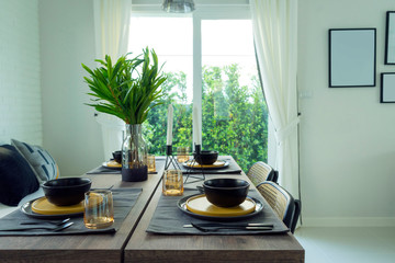 dining table with black and yellow plate setting in modern home.