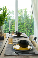 dining table with black and yellow plate setting in modern home.