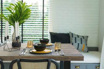 dining table with black and yellow plate setting in modern home.