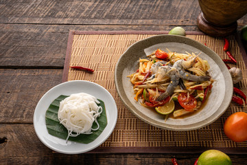 Thai papaya salad (Somtum) on table. Top view, free space for your message.