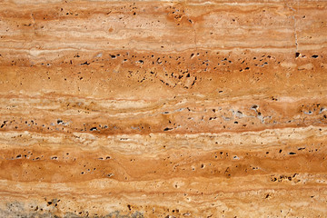 Fototapeta na wymiar Wall of travertine with stone layers of different colors. Close up architecture macro photography. Creative wallpaper photography.