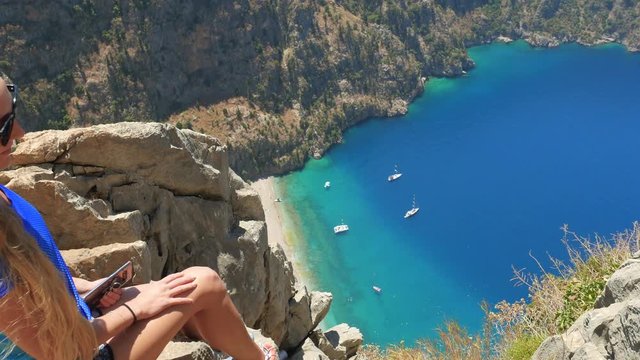 Woman traveller enjoying beautiful view of The Butterfly Valley from the top of the mountain