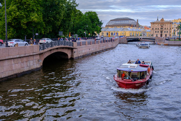 Naklejka premium boat sailing along the Fontanka river at sunset