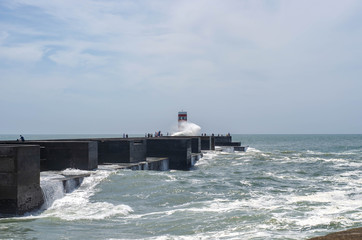 Lighthouse on a Porto city Portugal beach with dramatic waves of atlantic ocean