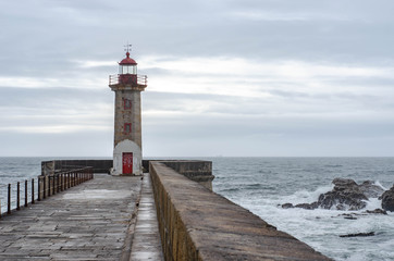 Lighthouse on a Porto city Portugal beach with dramatic waves of atlantic ocean
