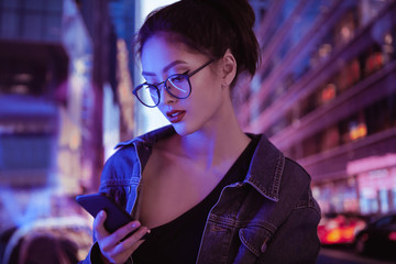 Woman Using a Smartphone in the City at Night
