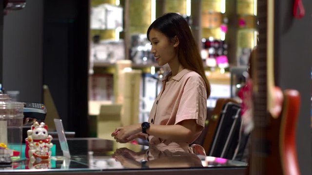 Young woman paying with NFC technology by smart watch contactless