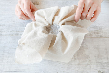 Woman shows how to make a floral arrangement with red roses and thuja twigs