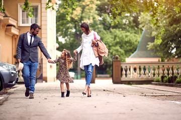 Back to school. pupil girl with backpack with her parents and going to school. - obrazy, fototapety, plakaty