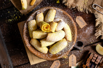homemade shortbread yellow baked rolled cookies or bagels with apple jam in wooden round plate