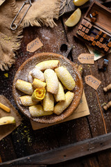 Fototapeta premium homemade shortbread yellow baked rolled cookies or bagels with apple jam in wooden round plate