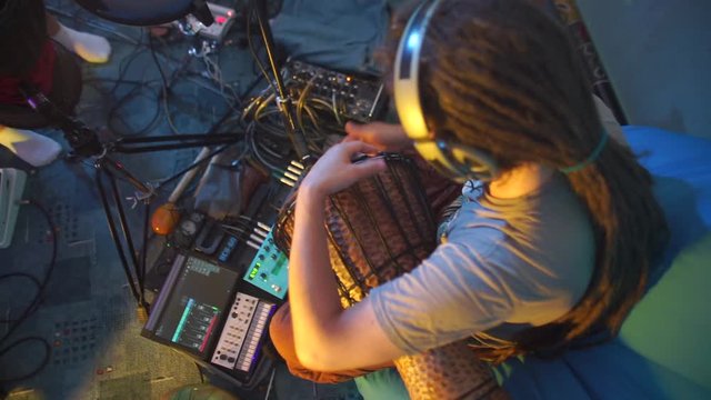 musician in dreadlocks playing darbuka