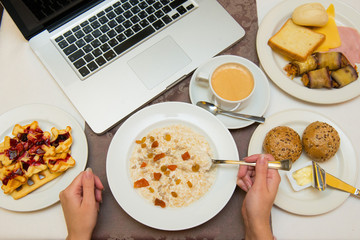 Top view multi-course breakfast near to laptop.