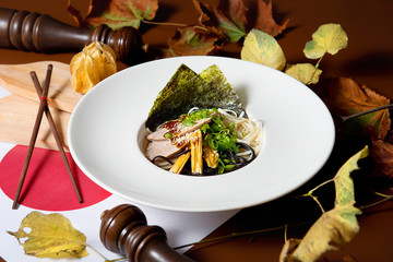 Pasta with bacon in a plate on a decorated table. Restaurant dishes.